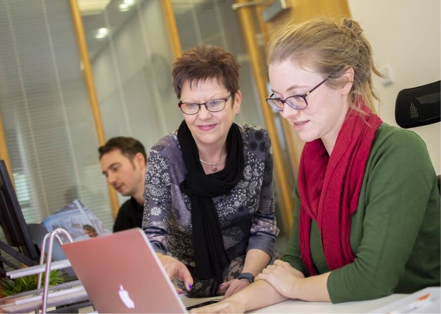 A teacher and student looking at a laptop computer screen