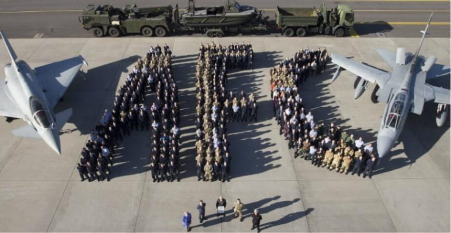 An aerial photo looking down on two miltary aircraft and vehichles with members of the armed forces stood in groups showing the letters A, F, C for the Armed Forces Covenant
