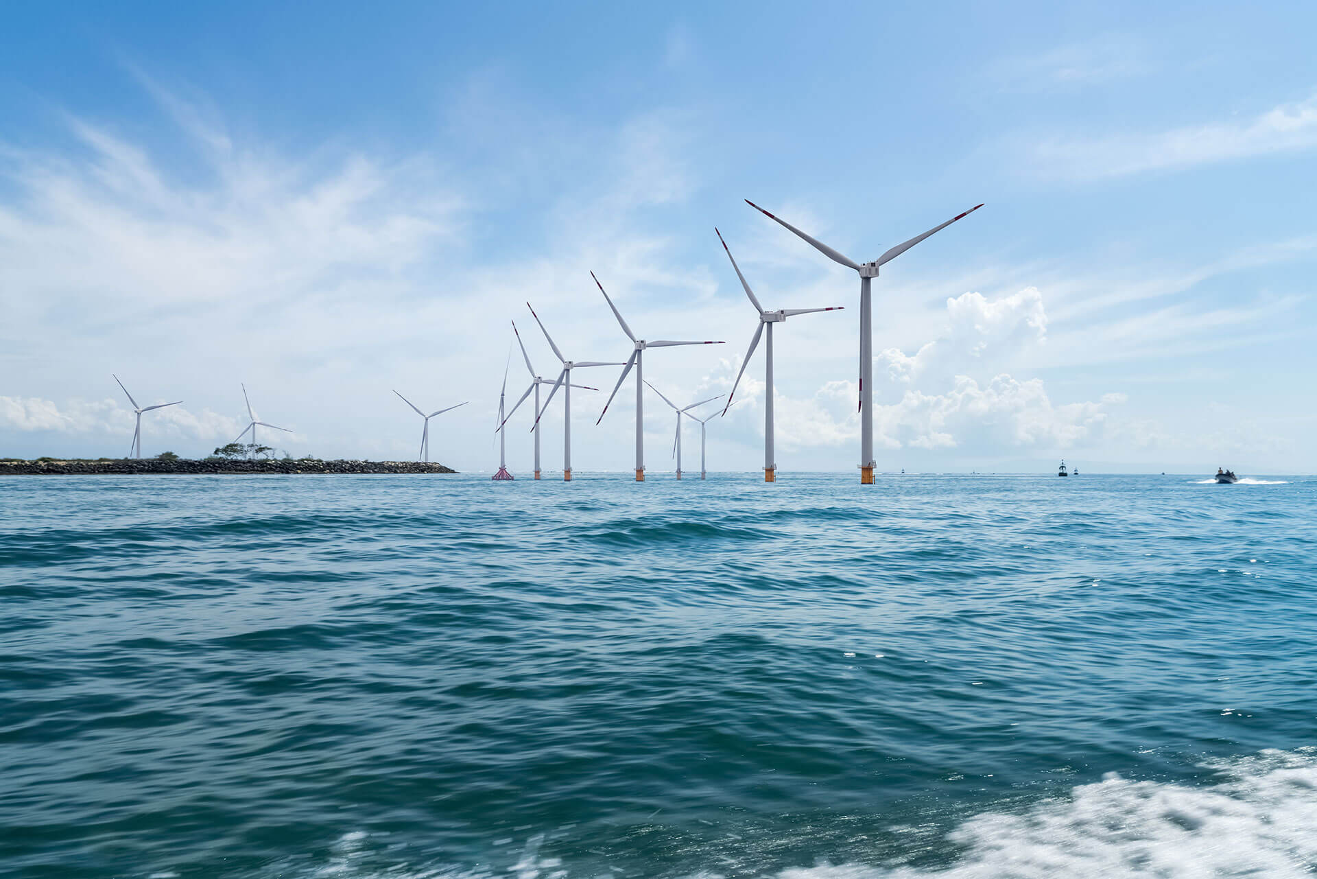 An offshore wind farm taken from a boat showing a number of wind turbines