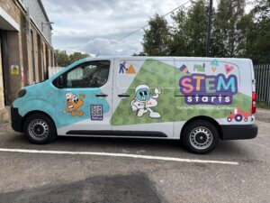 A transit van is covered with STEM Starts branding in bright block colours and characters depicting astronaut and worker in hard hat.